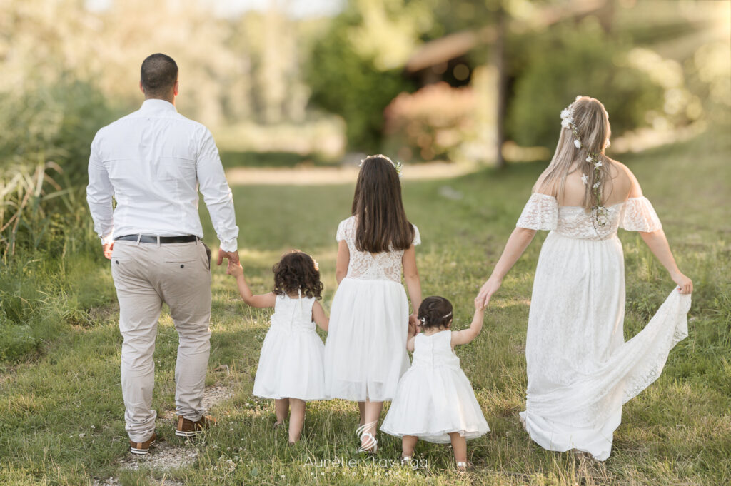 Famille en blanc dans un jardin, photographe baptême près de Voiron