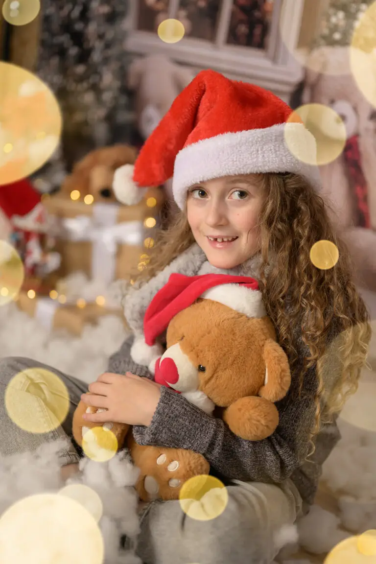 Portrait de Noël d’une petite fille et son ours en peluche, photographe en Isère